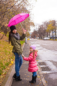 在雨天 小女孩与母亲在雨伞下行走妈妈季节乐趣生活女儿家庭天气喜悦女性女士图片