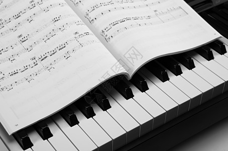 钢琴键和音乐书宏观音乐会仪表唱歌音乐教育黑色旋律行动学习图片