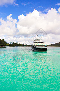 小船和巡洋舰在沿海的松绿水热带岛屿上岩石海景海洋天空血管娱乐旅行游艇闲暇甲板图片