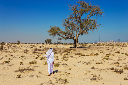阿拉伯沙漠冒险沙漠灰尘头巾树木天空旅行男性荒野游客图片