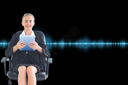商业女商务人士坐在带平板板板的摇摆椅上的综合图像数字黑色活力人士套装微笑女性触摸屏商务药片图片