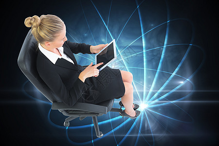 商业女商务人士坐在带平板板板的摇摆椅上的综合图像女性药片人士职业旋转辉光技术触摸屏连接女士图片