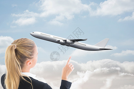 商业妇女指向某处的复合形象专注太阳浅色飞行职业蓝色航空计算机旅行天空图片