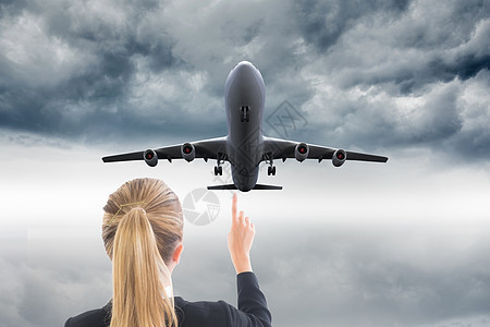 商业妇女指向某处的复合形象风暴飞机职业计算机手指商务航班飞行天空浅色图片