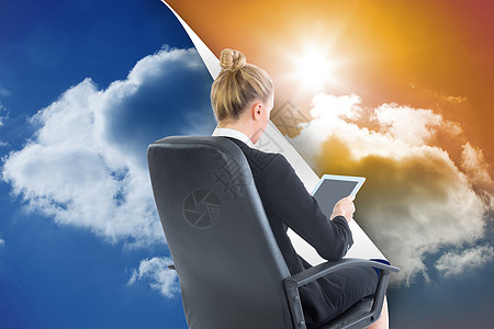 商业女商务人士坐在带平板板板的摇摆椅上的综合图像数字职业旋转天空阳光滚动蓝色套装药片触摸屏图片