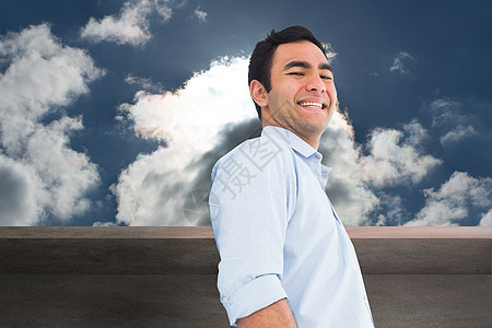 微笑着的随意男子站立的复合形象头发阳光天空膝盖口袋衬衫数字双手阳台蓝天图片