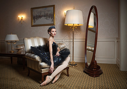 坐在扶手椅上坐着黑色塔图的芭蕾舞女图片