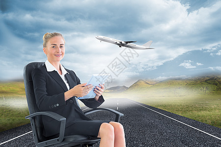 商业女商务人士坐在带平板板板的摇摆椅上的综合图像航空职业街道假期航班飞行女性飞机绘图草地图片