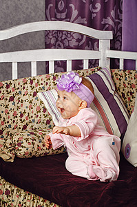 小女孩坐在沙发上童年承载者婴儿蝴蝶结软垫女性赞成幸福脚凳连体衣图片