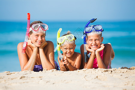 海滩上三个快乐的孩子风镜运动假期太阳姐姐乐趣说谎幸福男生浮潜图片