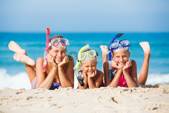 海滩上三个快乐的孩子天空享受乐趣太阳说谎浮潜面具男生潜水兄弟图片