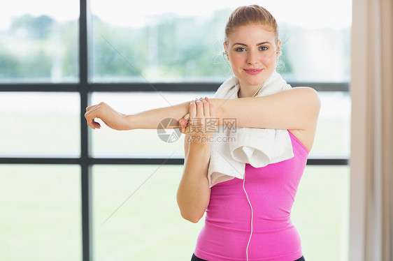 在健身房用毛巾围着颈部 伸手的妇女拉伸热身护理活动俱乐部运动服双手健身女性训练图片