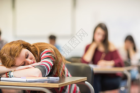 教室里一个睡着的女生在课堂上模糊的学生红发眼睛大学睡眠学习休息长发学校女士演讲图片