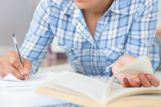 年轻女学生在躺在地板上执行任务的中小班女生中间部图片