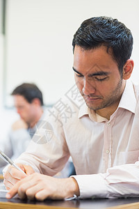 在课堂做笔记的成熟学生衬衫班级注意力大学男性桌子合作知识笔记本成人教育图片