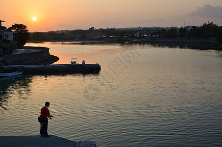黄光钓鱼娱乐港口太阳日落反射天空海滩爱好运动假期图片