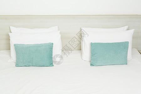 床上有白的 绿色的枕头栖息地商业游客客人地面寝具套房建筑学旅馆床垫图片