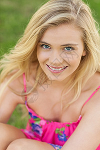 坐在草坪上的有吸引力的年轻女子肖像图片