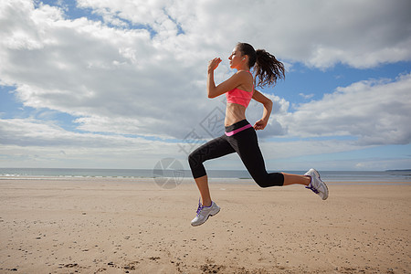 全身健康女子在沙滩上慢跑海洋活力跑步身体闲暇头发海岸线棕色马尾辫训练图片