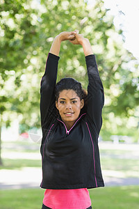 健康女性在公园锻炼期间伸展她的双手图片