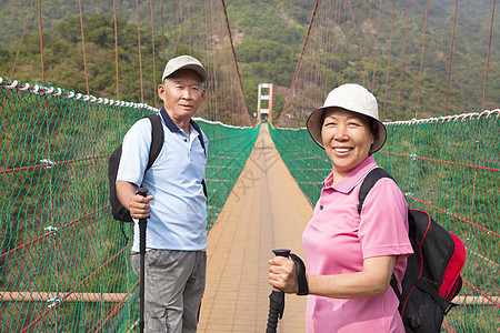 快乐的年长夫妇 在自然中走在桥上享受夫妻旅行闲暇森林男人微笑游客乐趣公园图片