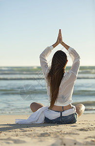 女人在海滩上做瑜伽女性冥想女孩海洋天空图片