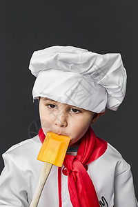 有趣的是 小男孩在厨房准备健康的食物 在灰背边的厨房里围裙蔬菜美食厨师饮食孩子家庭男生女性营养图片