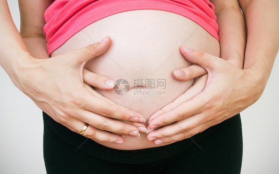 丈夫的手放在孕妇肚子上母性产妇怀孕腹部女性化手臂母亲女性红色分娩图片
