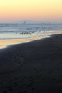 沙滩日落奥尔蒙海滩海岸天空太阳天气辉光波浪金子热带海洋旅行图片