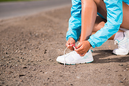 年轻女子在运动鞋上系鞋带成人活力锻炼赛跑者女性行动女孩活动闲暇身体图片