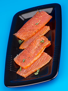 烟熏鲑鱼小吃宏观蓝色饮食橙子熏制迷迭香盘子红色海鲜背景图片