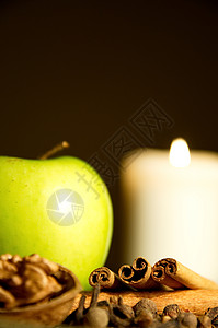 圣诞节苹果绿苹果 肉桂 胡桃和蜡烛传统营养饮食小吃食物情绪水果核桃烛光香料背景