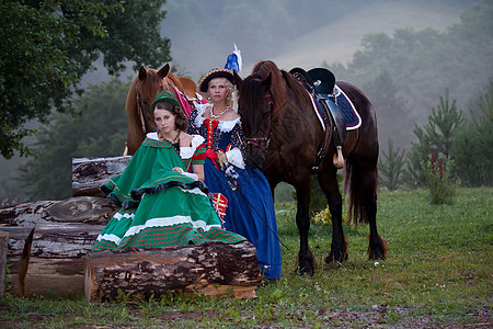 两个穿着皇家巴洛克礼服的女人骑着马闲暇哺乳动物骑术伴侣环境季节马术运动女士感情图片
