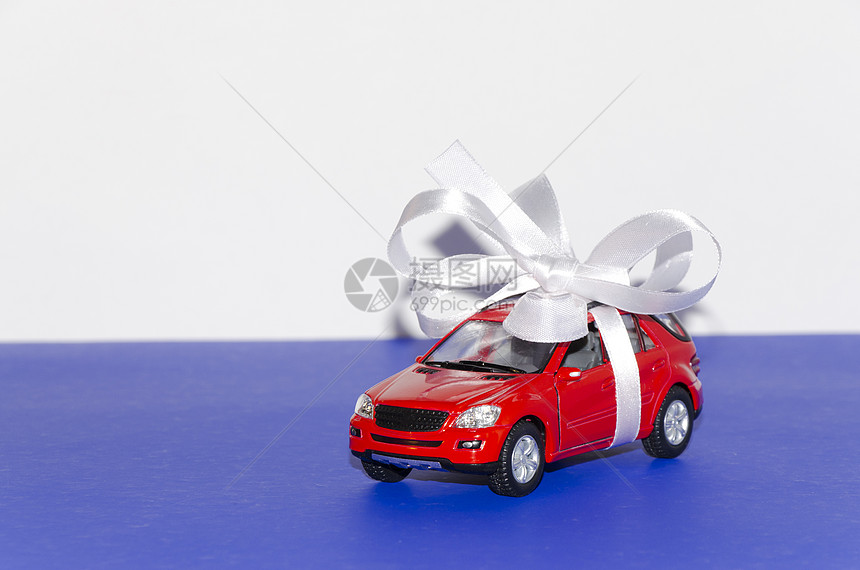 红色车 带白丝带玩具磁带宏观白色蓝色礼物桌子图片