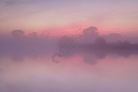 红雾在平静的湖面上日出图片