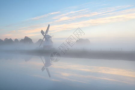 日出时浓雾中的荷兰风车农村农田蓝色日落文化风景天空旅行反射薄雾图片