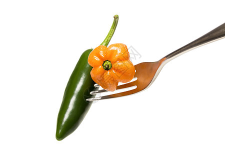 橙色和绿色热辣辣椒 在叉口上 孤立在白色图片