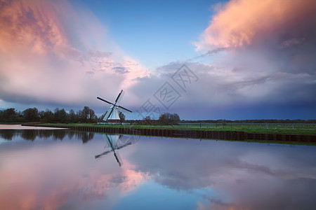 在荷兰风车上逐条河流的美丽日落图片
