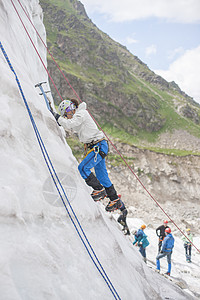 女孩爬上冰面锻炼逆境旅行运动绳索岩石女性征服顶峰风景图片