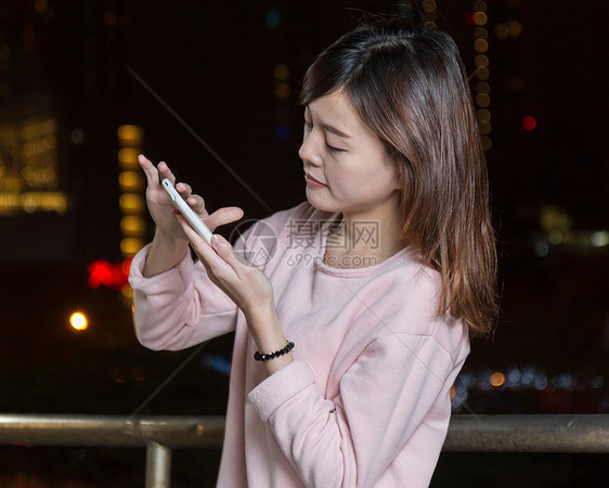 有吸引力的亚洲女性用亮光手机接着手机城市精英女士魅力女孩夜生活图片