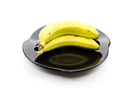 黑色陶瓷板上的新鲜黄色香蕉陶瓷食品饮食水果食物新鲜度盘子图片