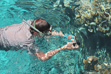 女摄影师潜水进入红海水快照呼吸相机浮潜面具红色波浪照片潜水员女性图片