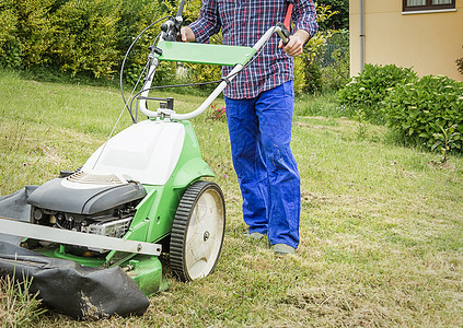 年轻人用割草机修剪草坪园丁植物男性工人服务机器院子园艺工具引擎图片
