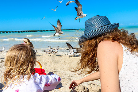 女儿妈妈玩得很开心海鸥玩具晴天女孩海岸热带孩子宝宝享受海洋图片