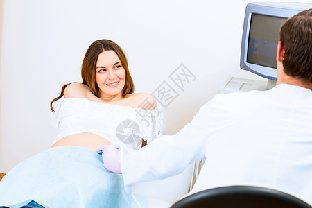 接受医生诊治的怀孕妇女微笑咨询生育力腹部肩膀医院家庭医师扫描测量图片