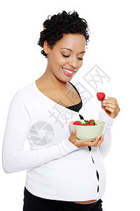 美容的年轻女人吃草莓的肖像母亲早餐父母女性食物营养腹部母性妈妈怀孕图片