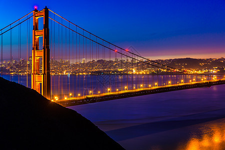旧金山金门大桥的日落 通过电缆景观悬崖建筑物吸引力蓝色交通海洋城市运输假期图片