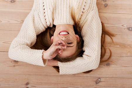 一位粗心大意的年轻caucosian女人的照片享受地面说谎乐趣快乐微笑金发喜悦房子幸福图片