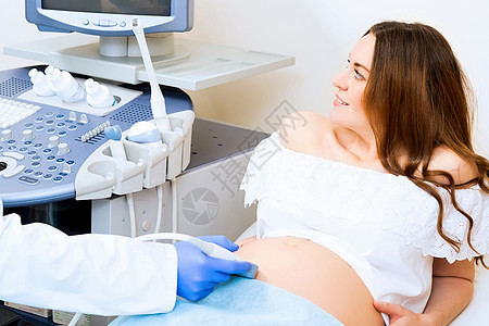 接受医生诊治的怀孕妇女微笑家庭卫生医院女性腹部女士病人检查诊所图片