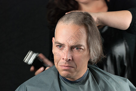 为癌症募捐者争取长头发剃发以获取癌症基金图片